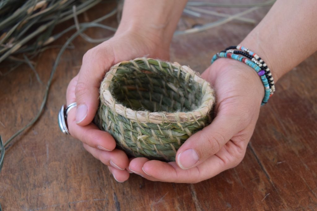 a beautiful tiny coiled basket with plant dye yarn