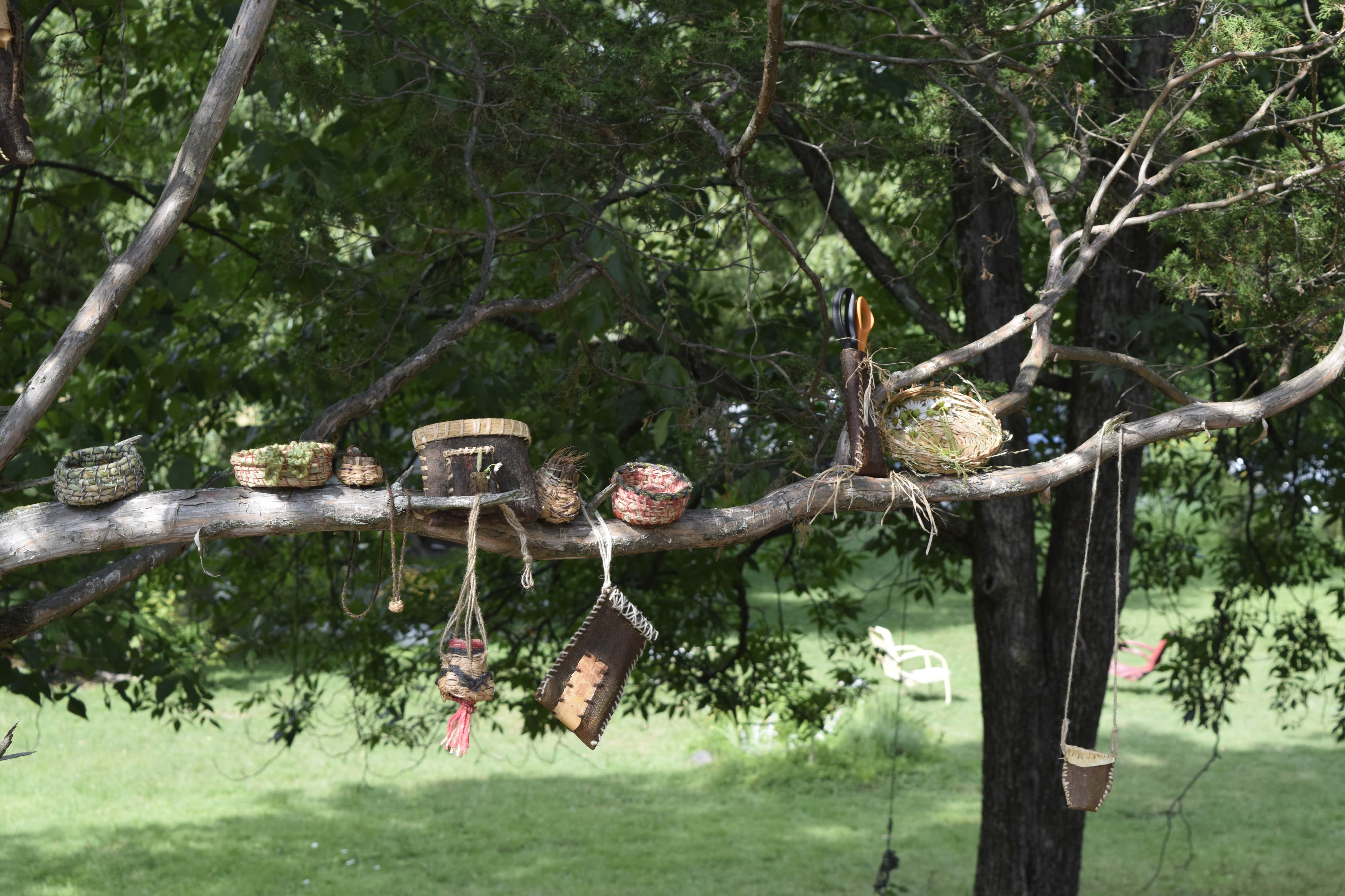 a tree covered in beautiful baskets, coiled, twined, and folded pine bark